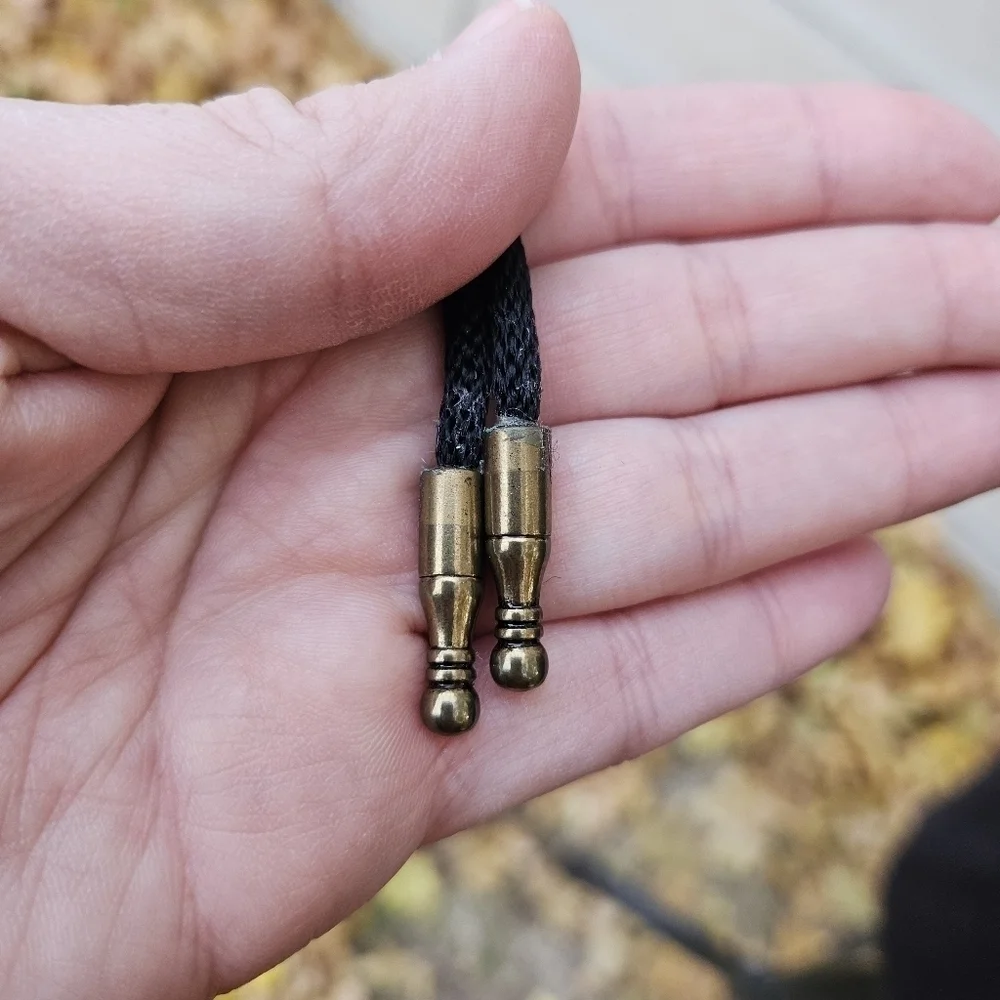 gold tone and brown leather abstract face bolo tie on black cord